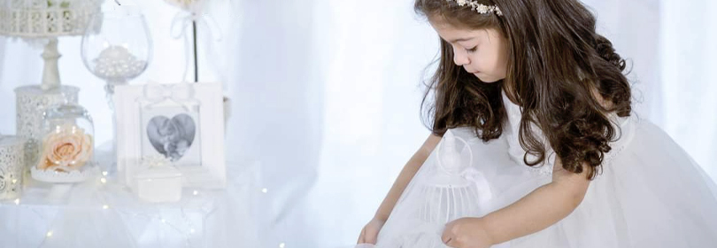 particolare di una bimba in abito da cerimonia